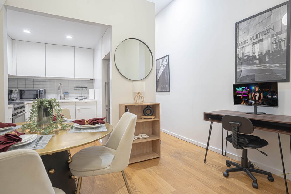Dining area flows into modern kitchen with dedicated workspace and contemporary furnishings.