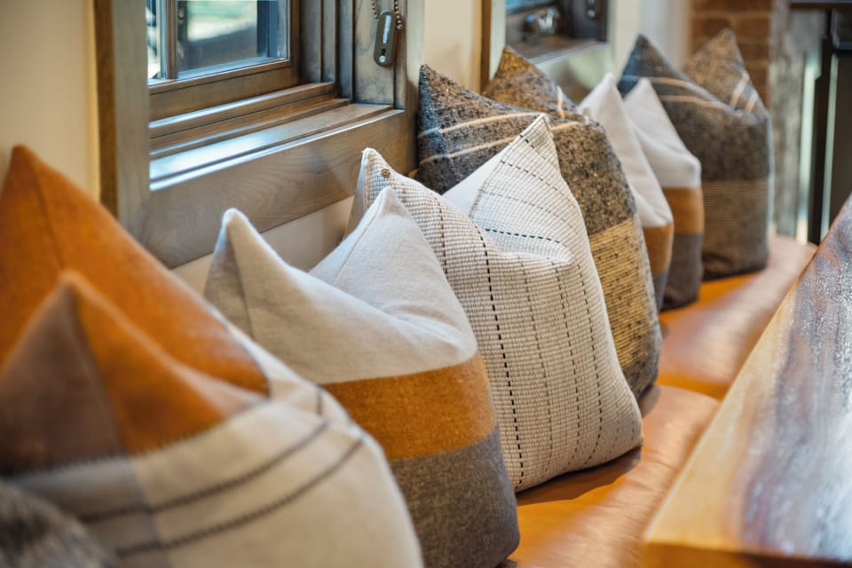 Cozy window seating with layered pillows offers a quiet corner to unwind and take in the surrounding views.