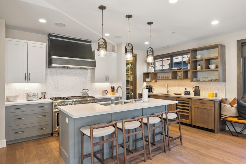 Bright and functional kitchen layout featuring ample prep space, custom cabinetry, and open shelving for a modern touch.