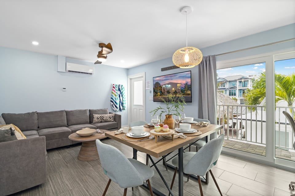 Sea Coast's Living Area, Featuring a Pull-Out Sleeper Couch, A Dining Table, and a Large HD TV