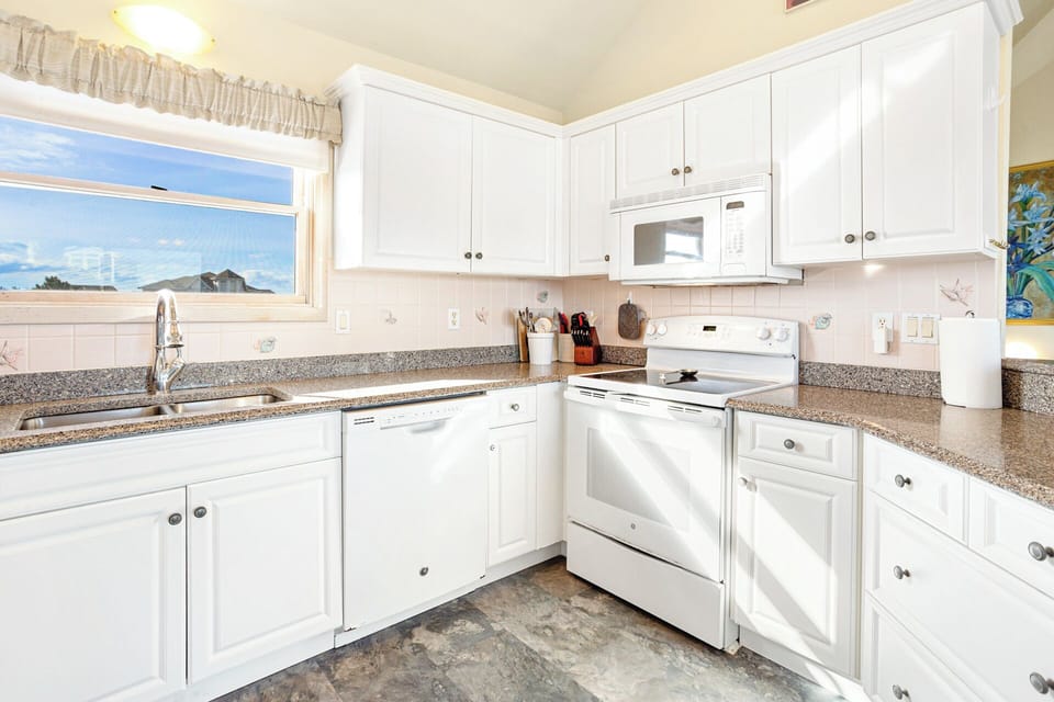 Kitchen: Fully equipped kitchen with modern appliances, breakfast bar seating, and plenty of prep space for family meals.