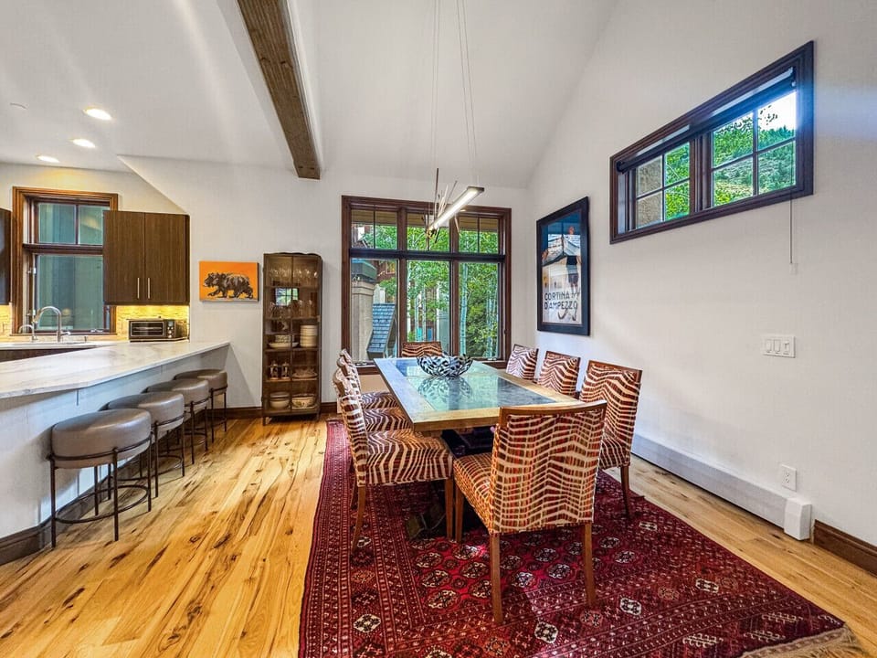 Natural light bathes your dining table and kitchen island where extra stools invite casual conversations. Quality dishes await in custom cabinets while the warm atmosphere sets the stage for memorable stay-in dinners with your group