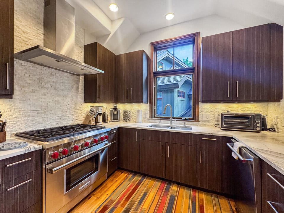 Cook like a chef in this gourmet kitchen featuring Wolf oven and gas cooktop, complete with dedicated coffee station and high-end appliances. Village views through the windows inspire culinary creativity in your home away from home