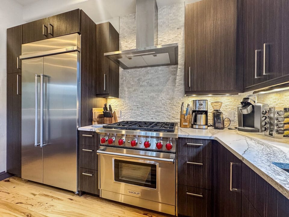 Discover culinary luxury up close, Wolf stove and stainless steel refrigerator anchor this chef`s paradise. The dedicated coffee station and spice collection invite morning rituals and gourmet creations, while expansive counter space handles any feast