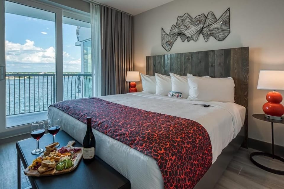 Unwind in plush bedding with breathtaking waterfront balcony views.