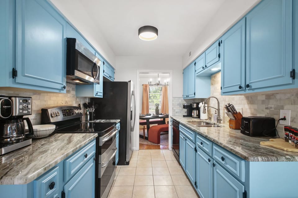 Whip up a culinary masterpiece (or just toast some pop-tarts!) in our vibrant kitchen! With stylish blue cabinets and everything you need, it's ready for your morning coffee rituals and delicious vacation meals.