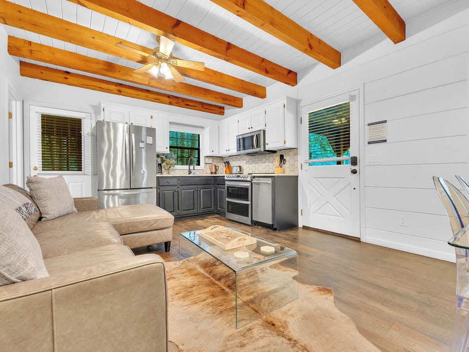 Open concept living room with a leather couch and modern appliances.