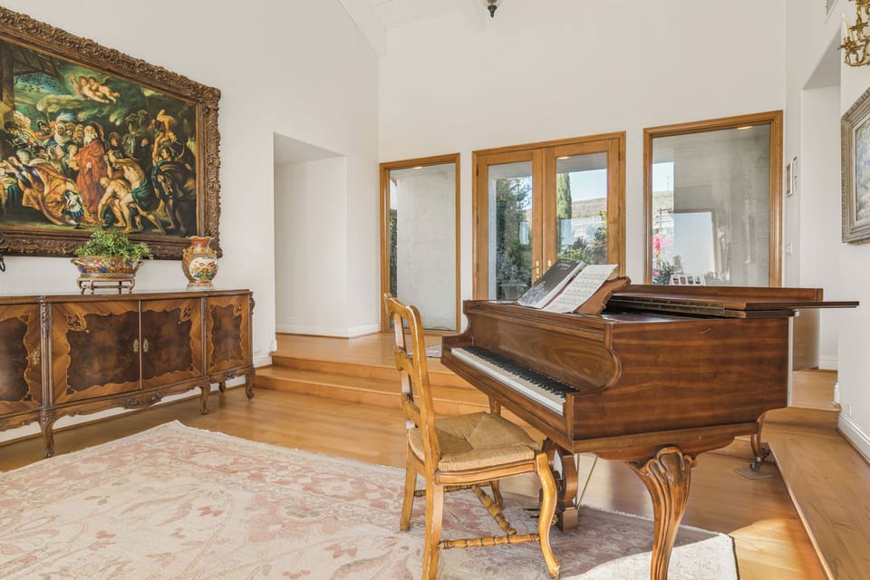Elegant sitting area featuring a grand piano and classic furnishings.
