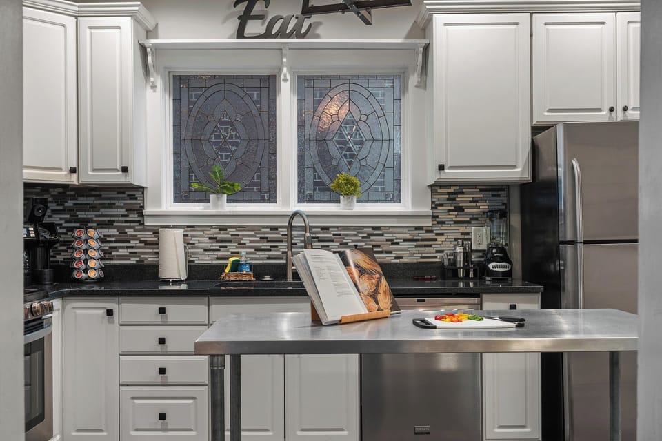 Kitchen: White cabinets, stainless appliances, and tile backsplash!