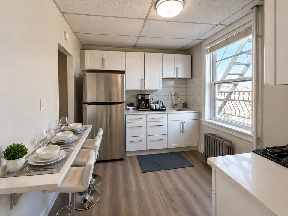 Bright kitchen w/ stainless appliances, breakfast bar & big window