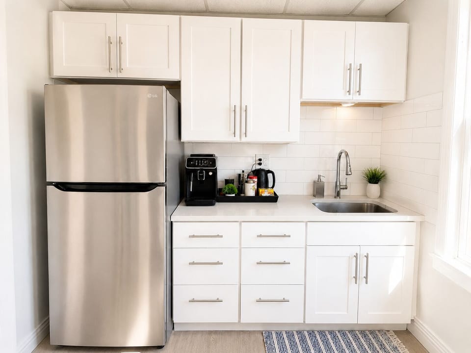 Bright modern kitchenette with stainless fridge and coffee station