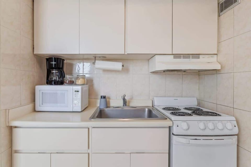 You'll find a fully equipped, compact kitchenette with a stove, microwave, and coffee maker, perfect for preparing light meals and snacks during your stay