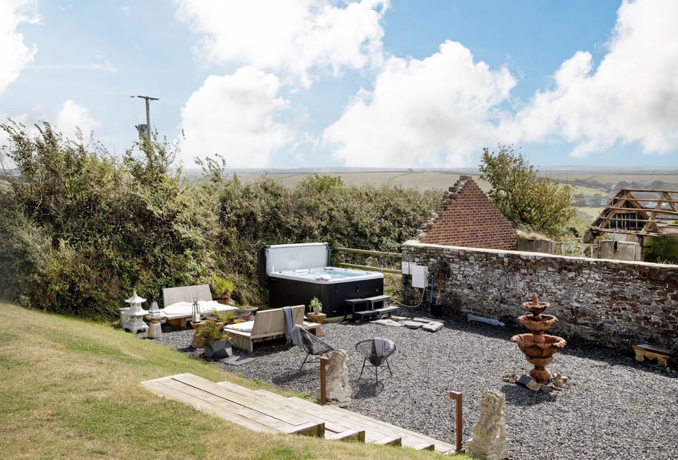 Berry Barn, Bideford. Step into a thoughtfully landscaped communal garden, where stylish outdoor seating invites you to unwind in comfort. At the heart of the space, a luxurious hot tub offers the perfect place to relax and soak, all while taking in breat