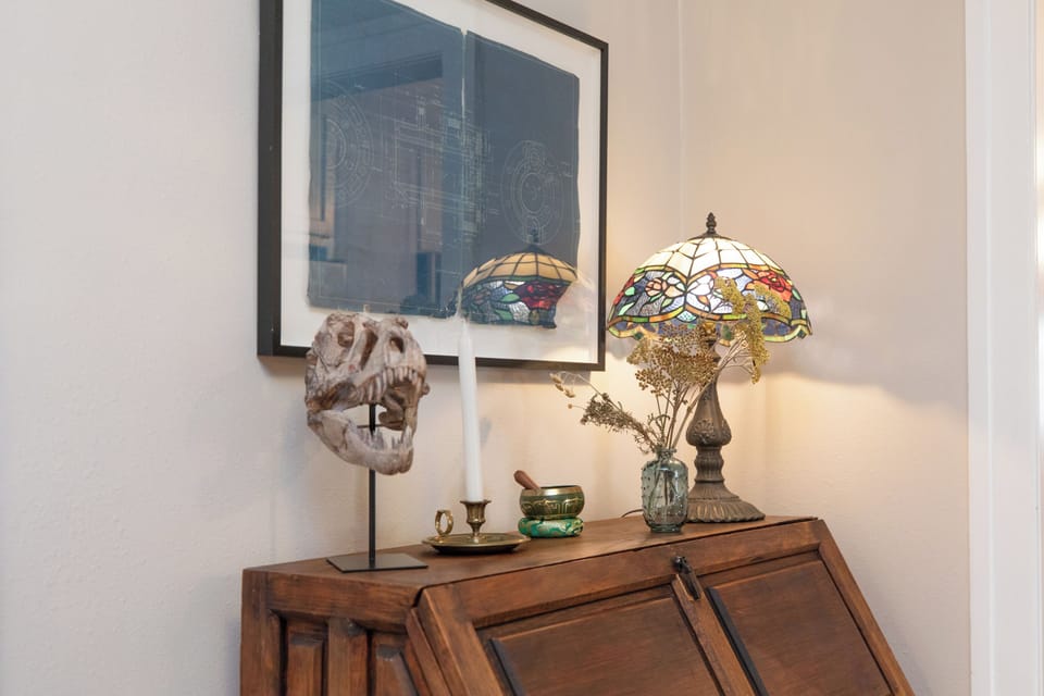 Charming vintage decor with a stained-glass lamp, dried florals, and unique art.
