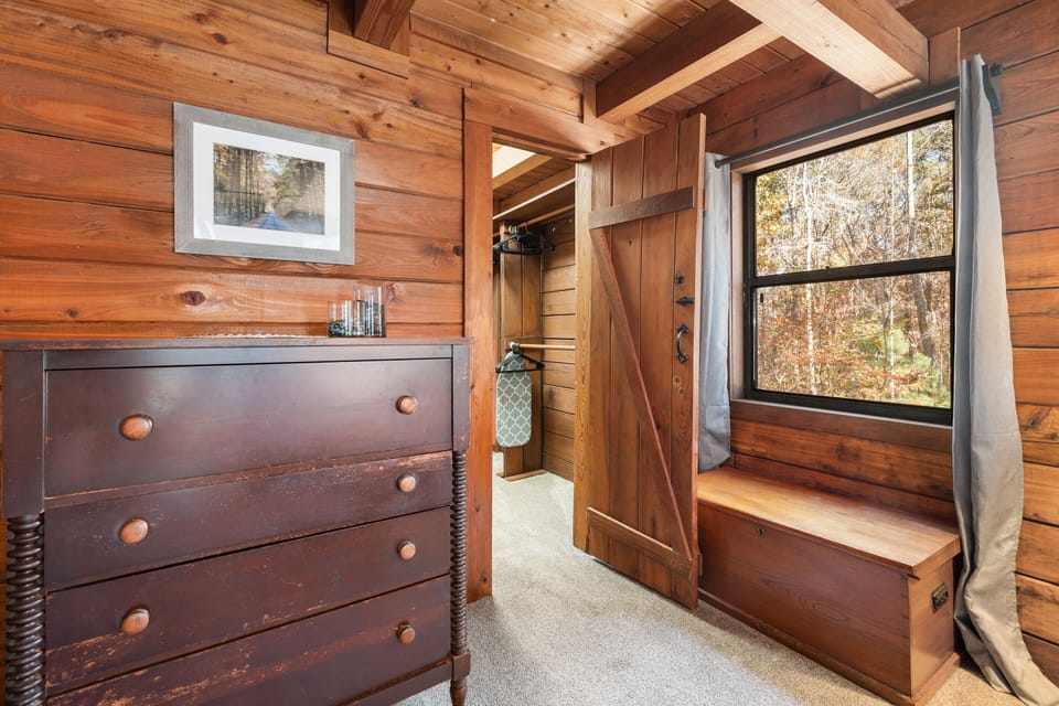 Dresser and extra blankets, closet leading to lower full bath