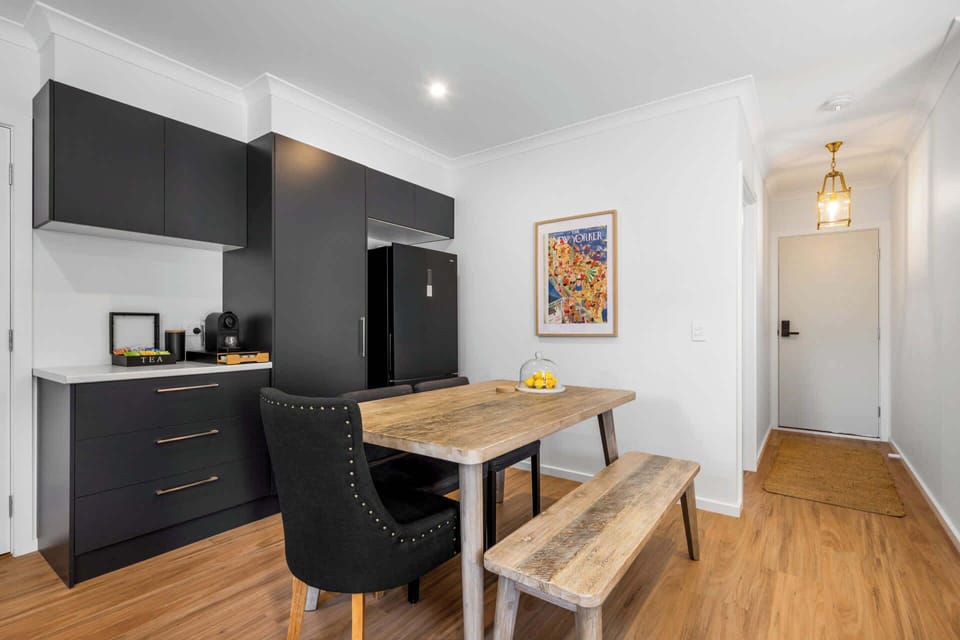 Open plan kitchen & dining featuring stainless steel appliances and coffee pod machine. 