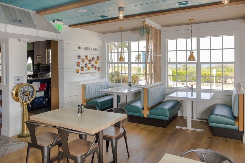 Sip coffee by sunny windows in cozy booth seating.