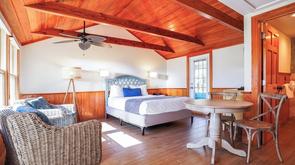 Unwind in a sunlit bedroom with warm wood ceilings.