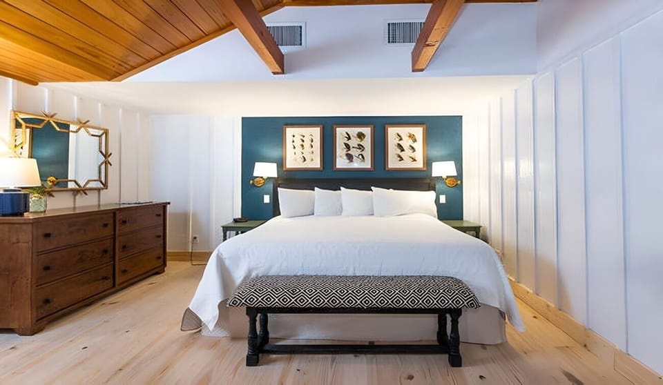Unwind beneath warm wood beams in your serene king retreat.