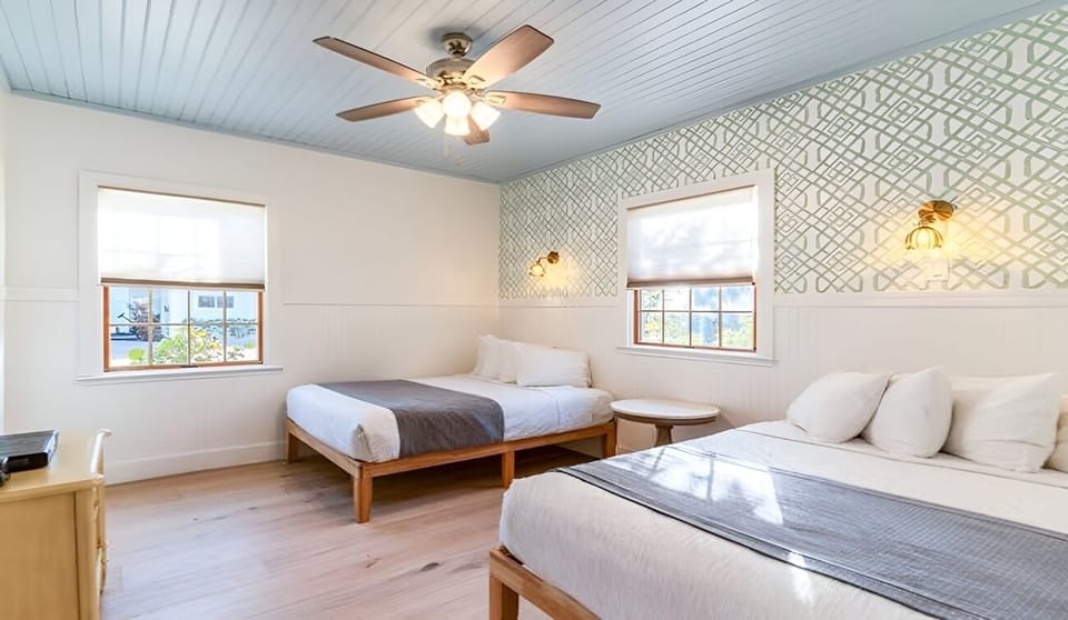 Spread out comfortably with two beds in a sunlit room.