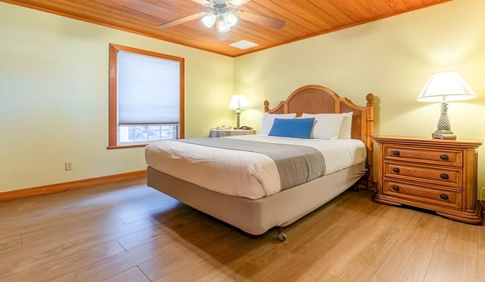 Unwind in a quiet bedroom with warm wood ceilings.
