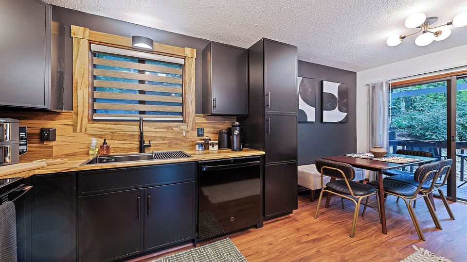 Stylish black kitchen with wood accents & open dining setup