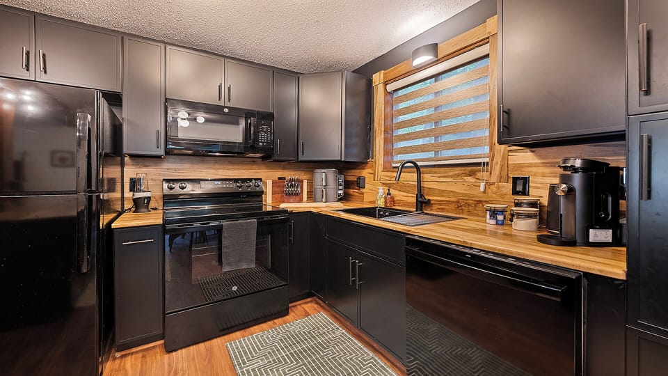 Modern kitchen with bar seating & cozy dining table for guests