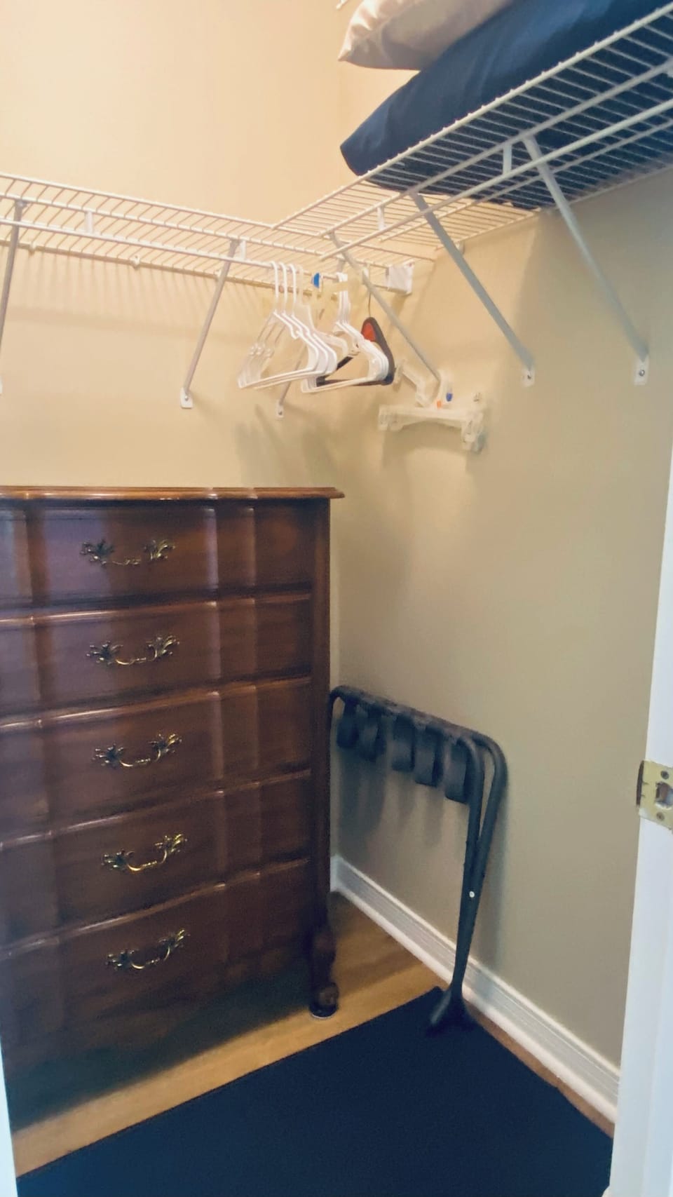 Upstairs walk in closet with storage and extra pillows.