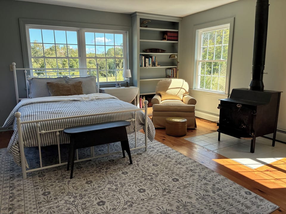 Primary Bedroom with private bathroom, wood stove, and outdoor access. 