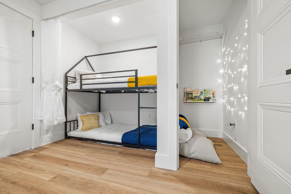 Kids’ favorite spot- bunk beds with privacy curtains, fairy lights, and a reading nook for cozy nights.