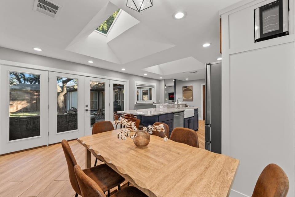 Natural light pours in through the skylight and glass doors, creating a bright, welcoming space to gather for meals and conversation.