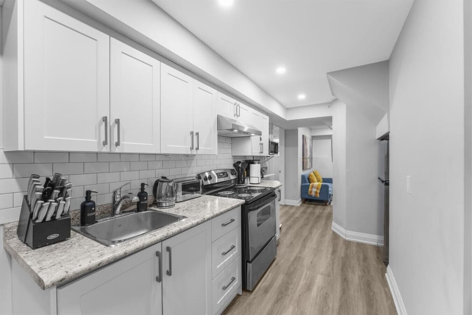 Whip up a great meal in this fully-equipped modern kitchen. Featuring sleek white cabinets, stainless steel appliances, and everything you need for breakfast or dinner. Cook with ease during your stay!