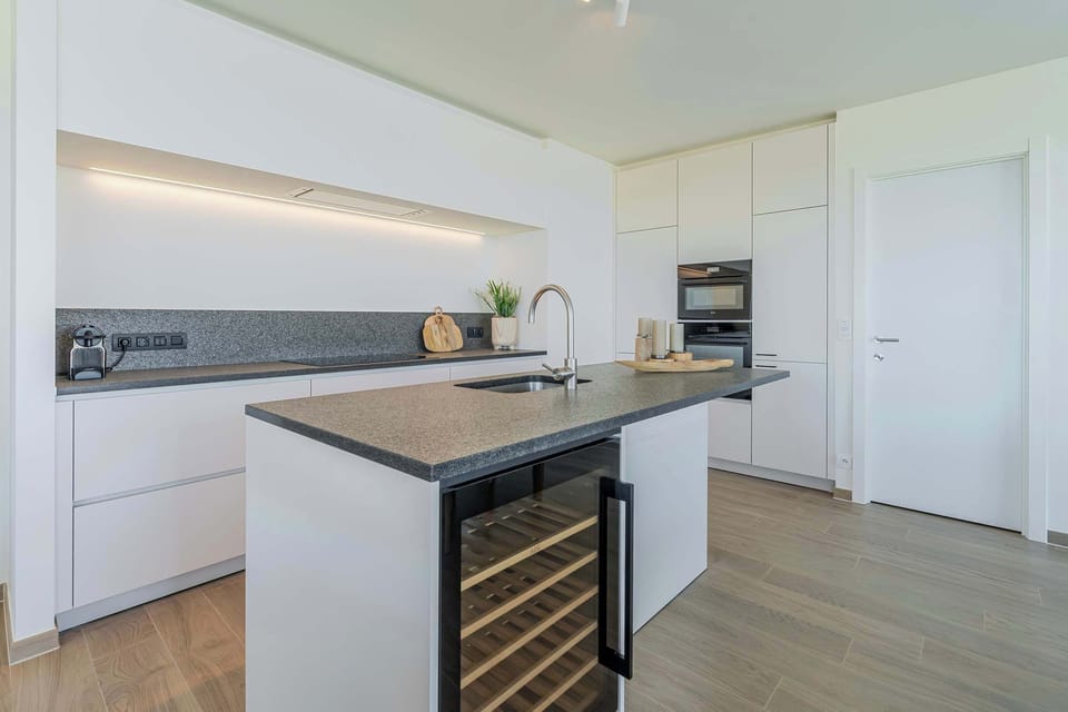 Modern kitchen with wine fridge and clean design.