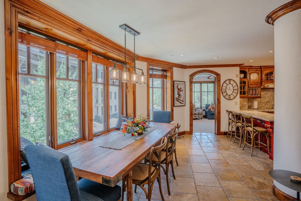 The dining area features a large table with seating for nine, ideal for family dinners or group gatherings