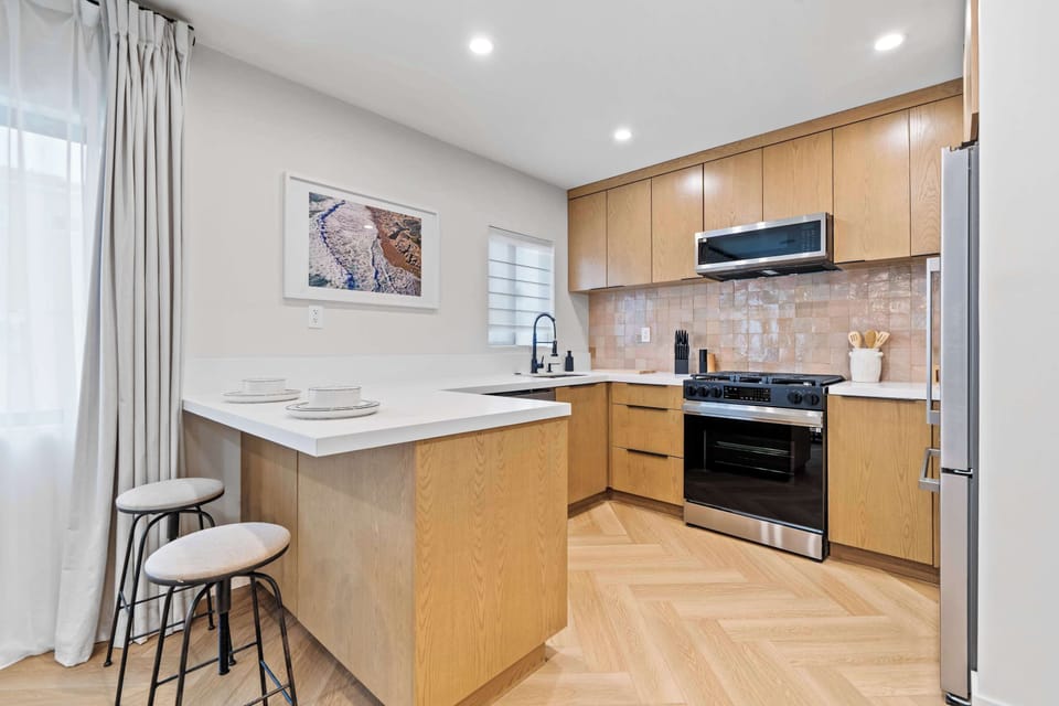 Prepare meals with ease in this modern, fully-equipped kitchen. It features a gas stove, full-size refrigerator, and a breakfast bar for casual dining.