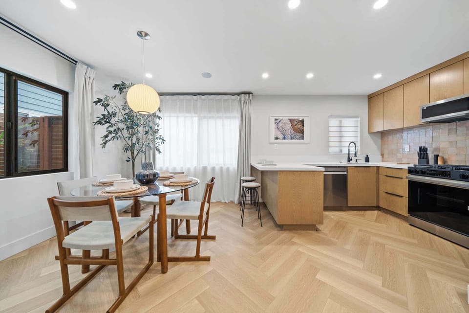 
Cozy, sunlit dining area with a modern kitchen, perfect for morning coffee or a home-cooked meal. Enjoy the bright, open space.