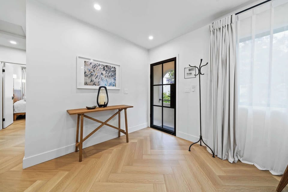 
Welcome home! This bright, inviting entryway features a stylish console table and coat rack, leading into the rest of the beautifully designed space.