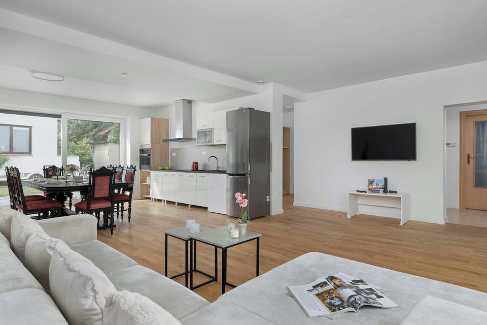 Bright and spacious living room with large windows and stylish wooden flooring.
