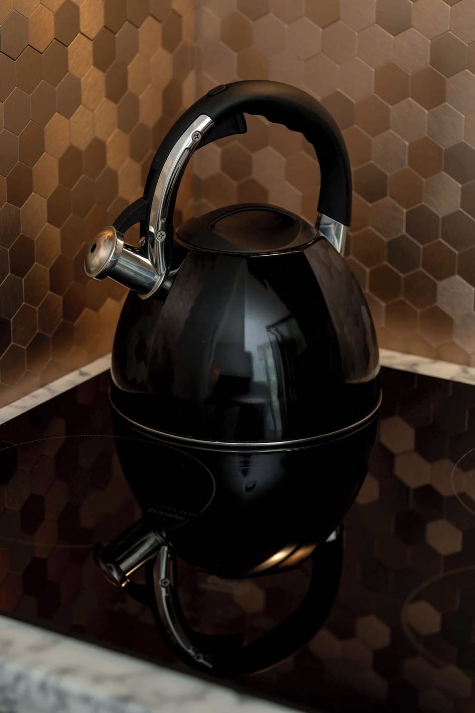 A unique close-up of a black kettle placed on a counter. Industrial design elements stand out.