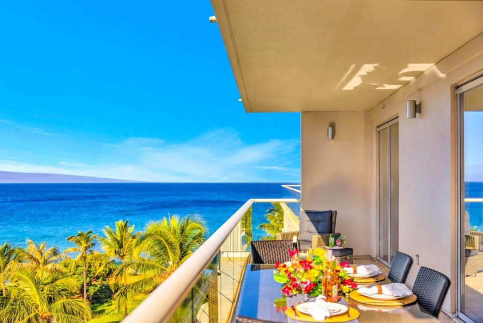HKH-504 Expansive lanai with partial ocean views and lush palm tree scenery, perfect for al fresco dining or evening drinks with a breeze.