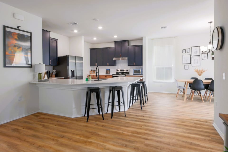 Fully equipped kitchen with sleek black cabinets and stainless steel appliances, ready for cooking or entertaining.