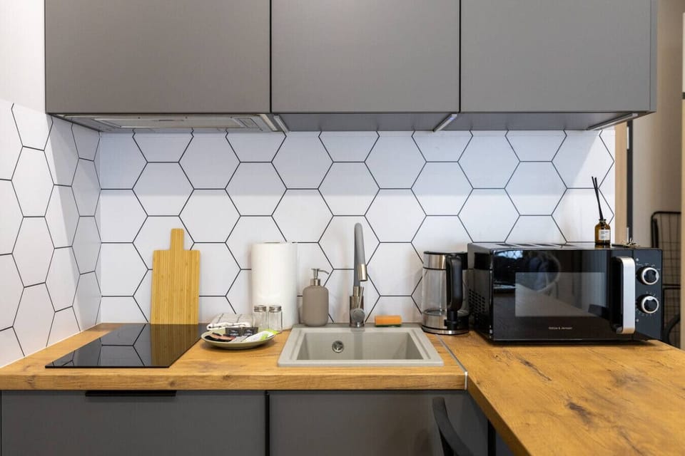 Modern Kitchen Area – Fully equipped with stove, microwave, kettle, and dining bar for two | Book Now with RENTUJEMY.COM