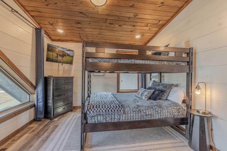 Full-sized bunk room is arranged to make group stays comfortable, blackout curtains keep it dark when needed.