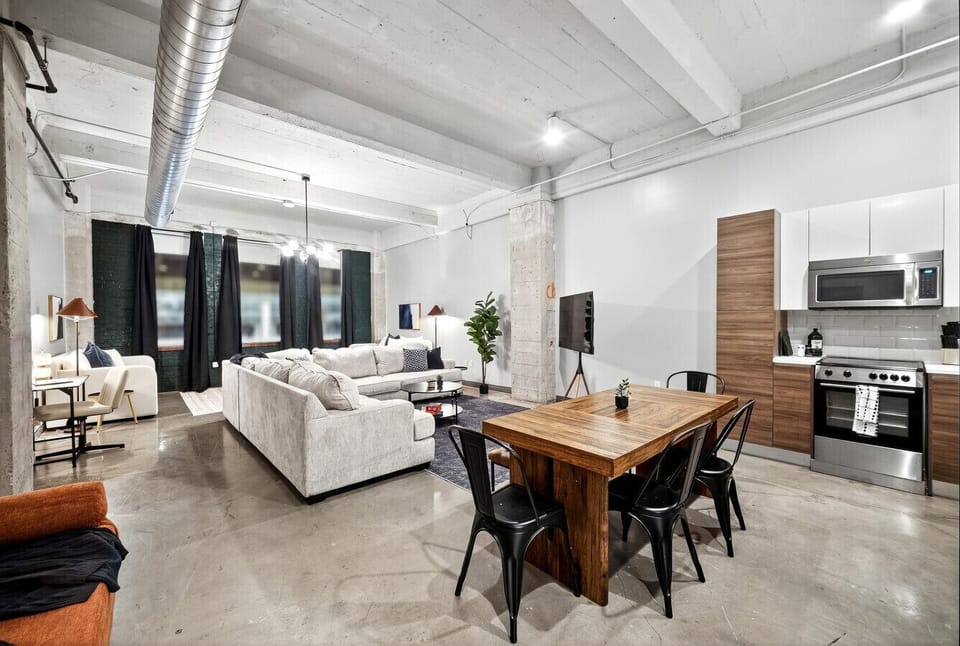 “Loft living” — Experience open-concept living with modern dining, a cozy lounge, and a fully stocked kitchen all in one welcoming space