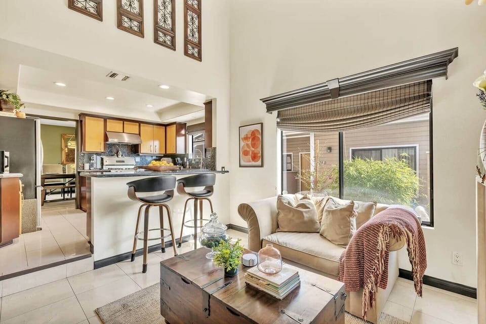 Open-concept kitchen with island seating, modern stools, and natural light.