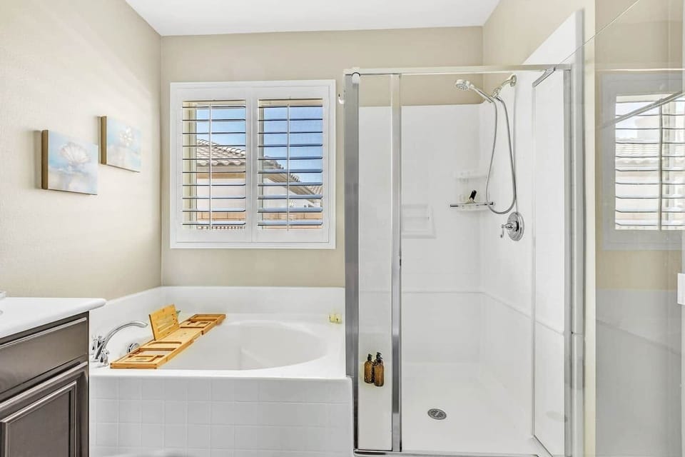 Ensuite bathroom with walk-in shower, soaking tub, and bright windows.