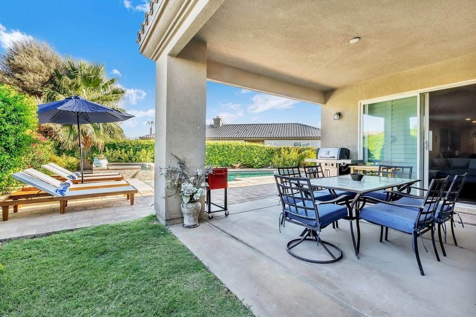 Patio with BBQ grill, dining area, and loungers for relaxed outdoor living.