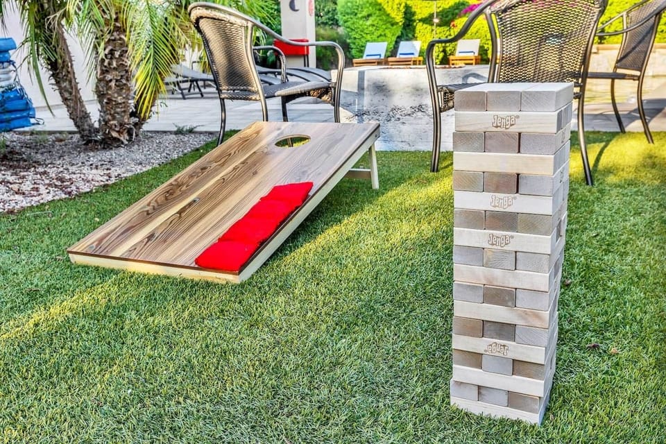 Giant tumbling blocks and cornhole set for fun on the sunny lawn.