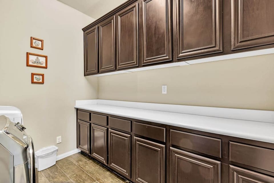 Spacious laundry room with ample countertop space and extensive cabinetry - perfect for sorting and 
