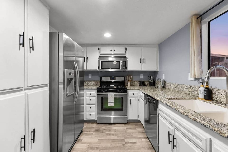 Cook with ease in a fully stocked kitchen with stainless steel appliances and granite counters.